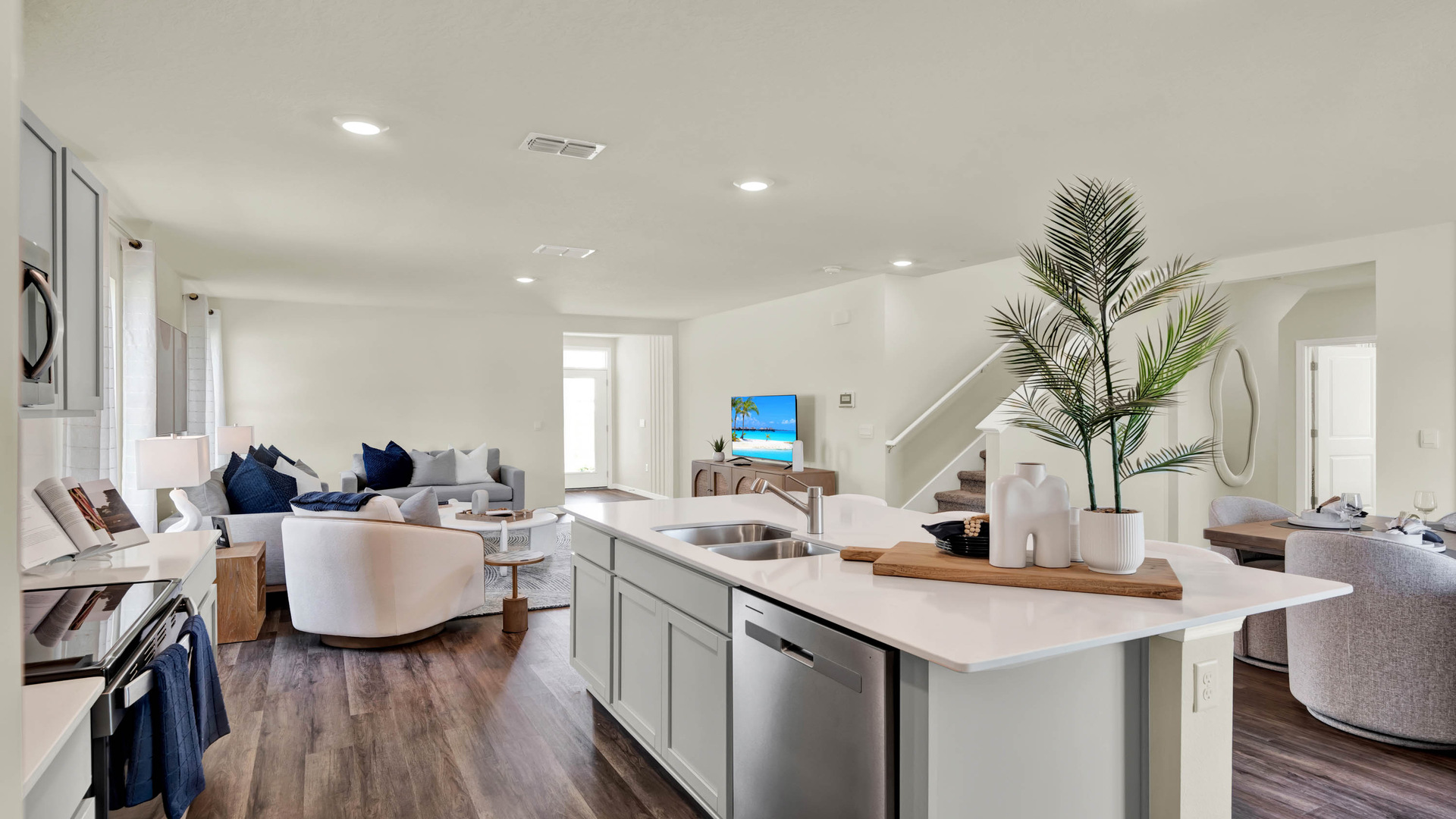Kitchen with island seating, quartz counters, spacious pantry and stainless steel appliances.