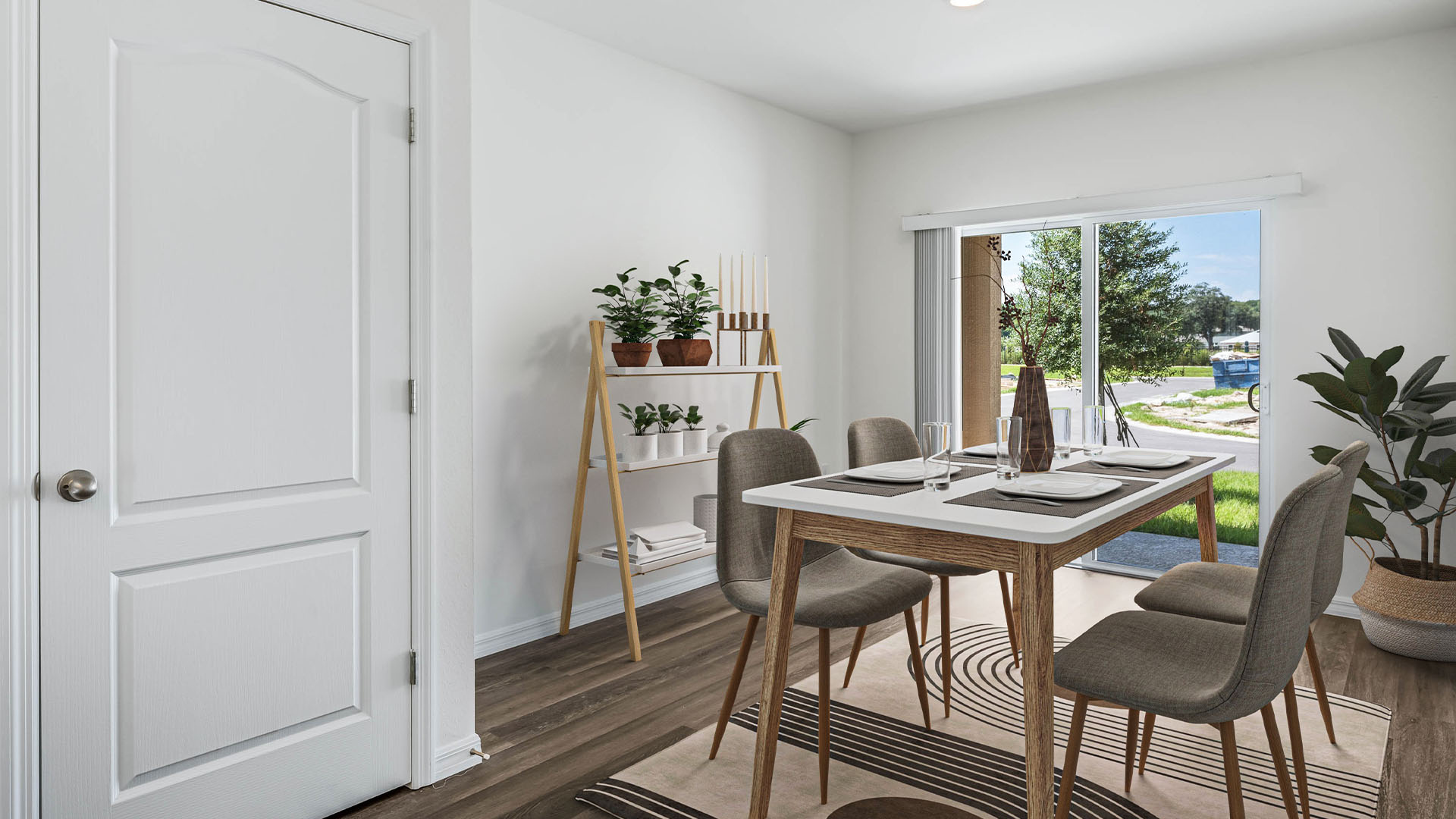Kitchen with island seating, quartz counters, spacious pantry and stainless steel appliances overseeing living area.