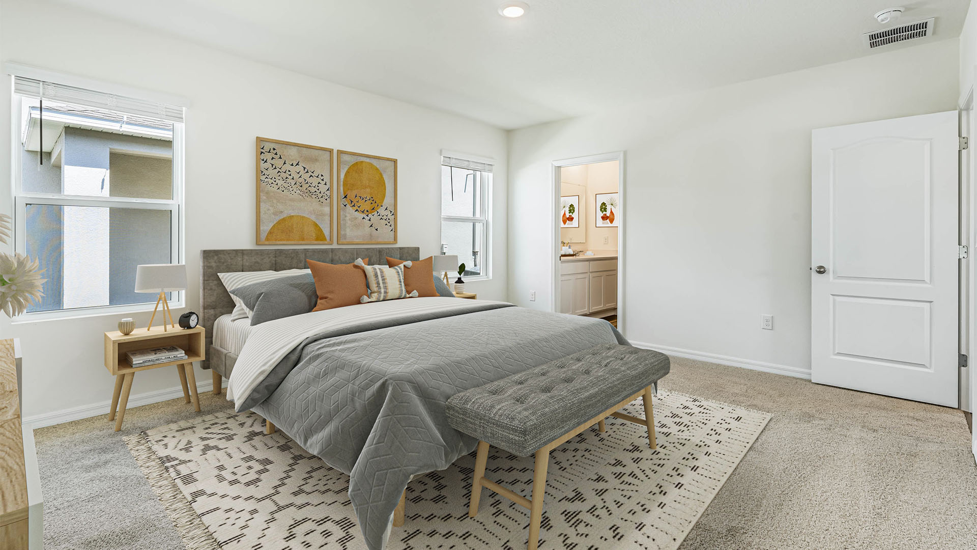 Spacious primary bedroom with king size bed, carpet flooring, natural lighting showing access to primary bathroom.