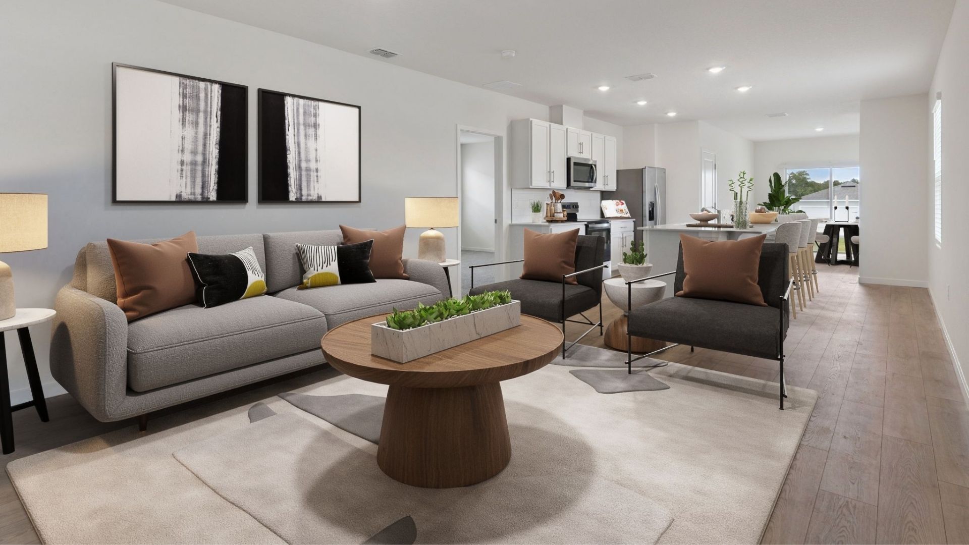 Living area with laminate Flooring overseeing kitchen and dining room table.