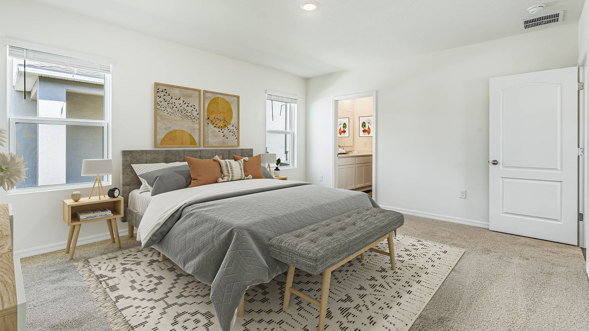 Spacious primary bedroom with king size bed, carpet flooring, natural lighting showing access to primary bathroom.