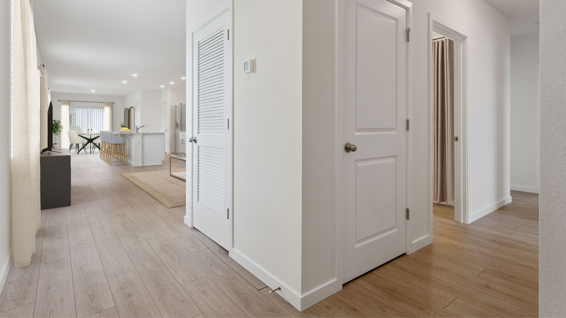 Home entry way seeing hallway leading to rooms and living area and kitchen