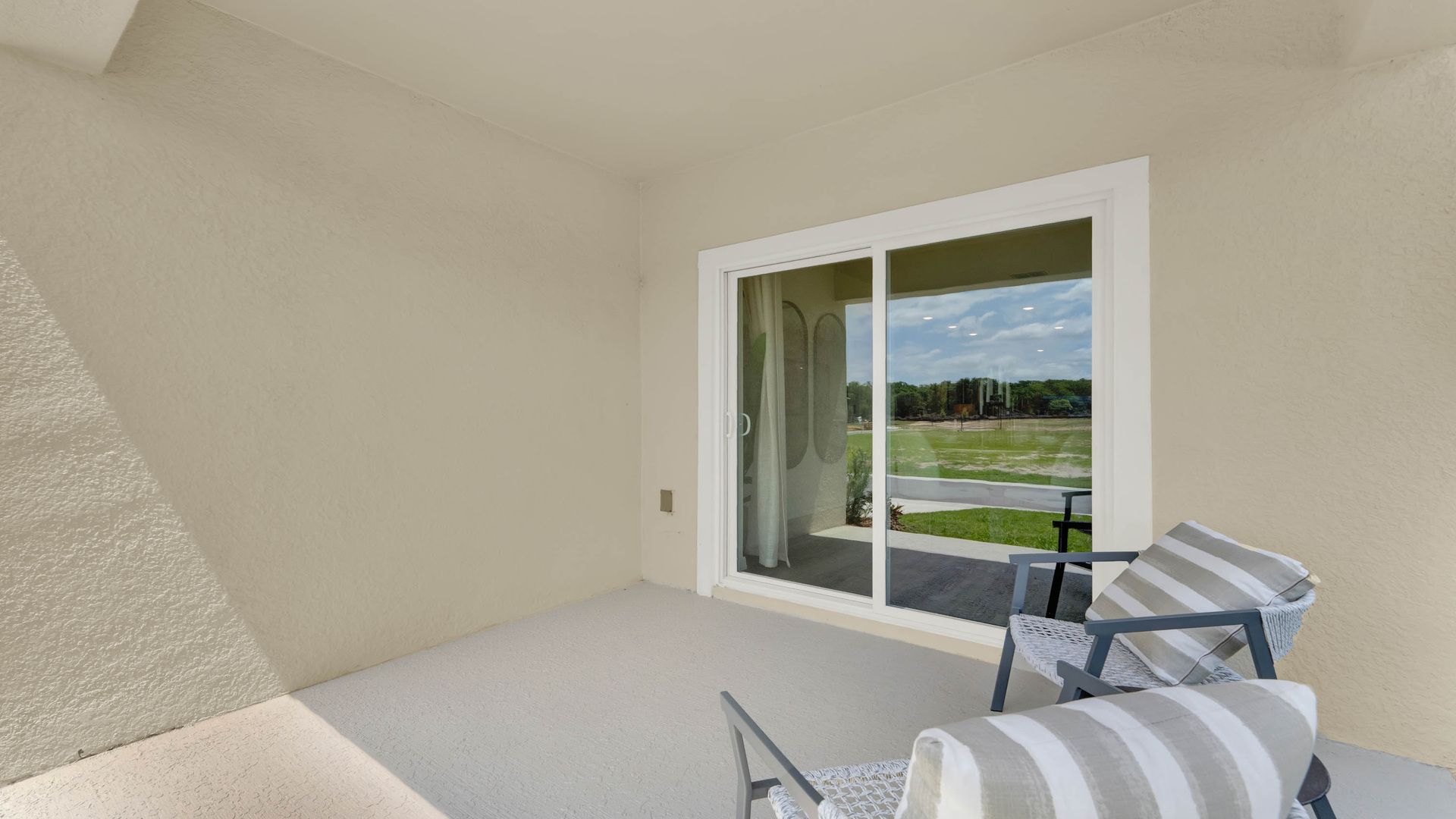 Rear of home with porch seating and sliding doors.