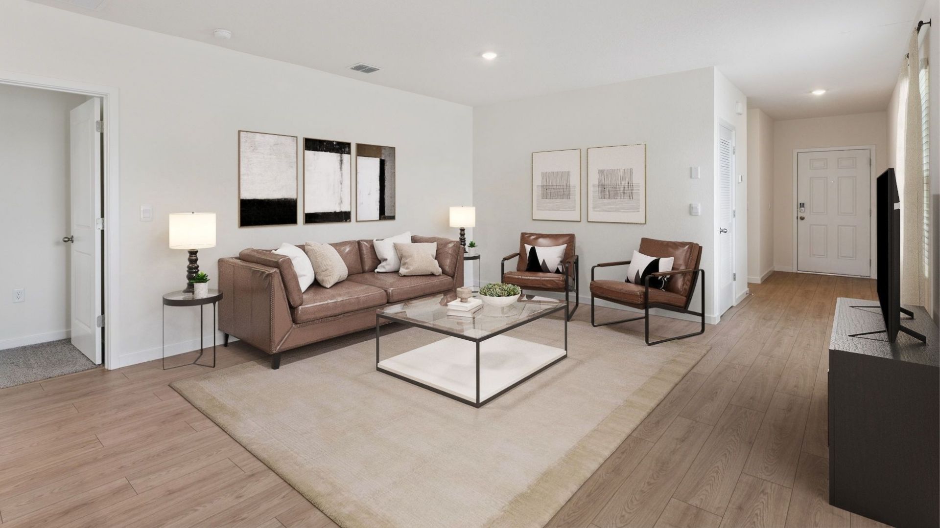 Living area with couch seating overseeing kitchen and dining room with laminate flooring.