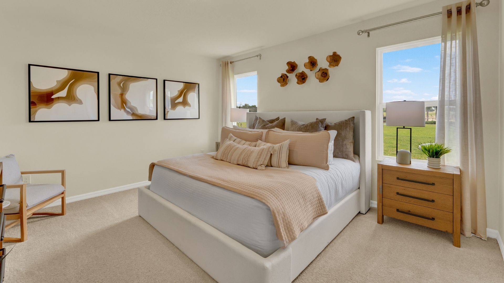 Spacious primary bedroom with king size bed, carpet flooring, natural lighting.