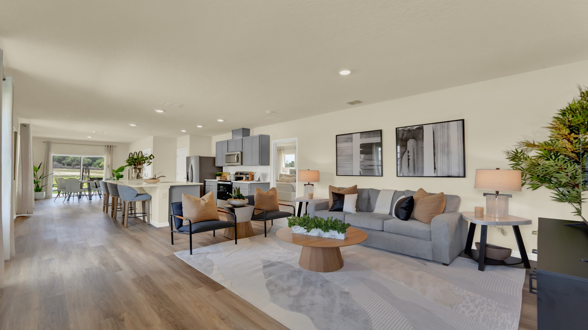 Living area with couch seating overseeing kitchen and dining room with luxury vinyl plank flooring..
