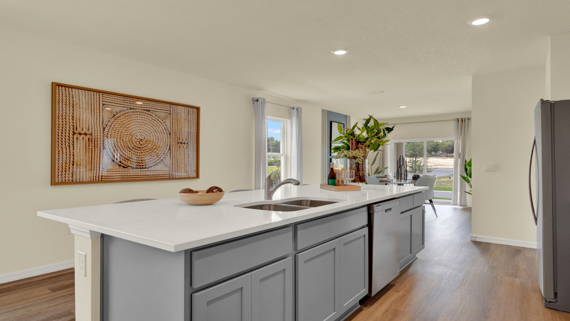 Kitchen with island seating, quartz counters, spacous pantry and stainless steel appliances. .