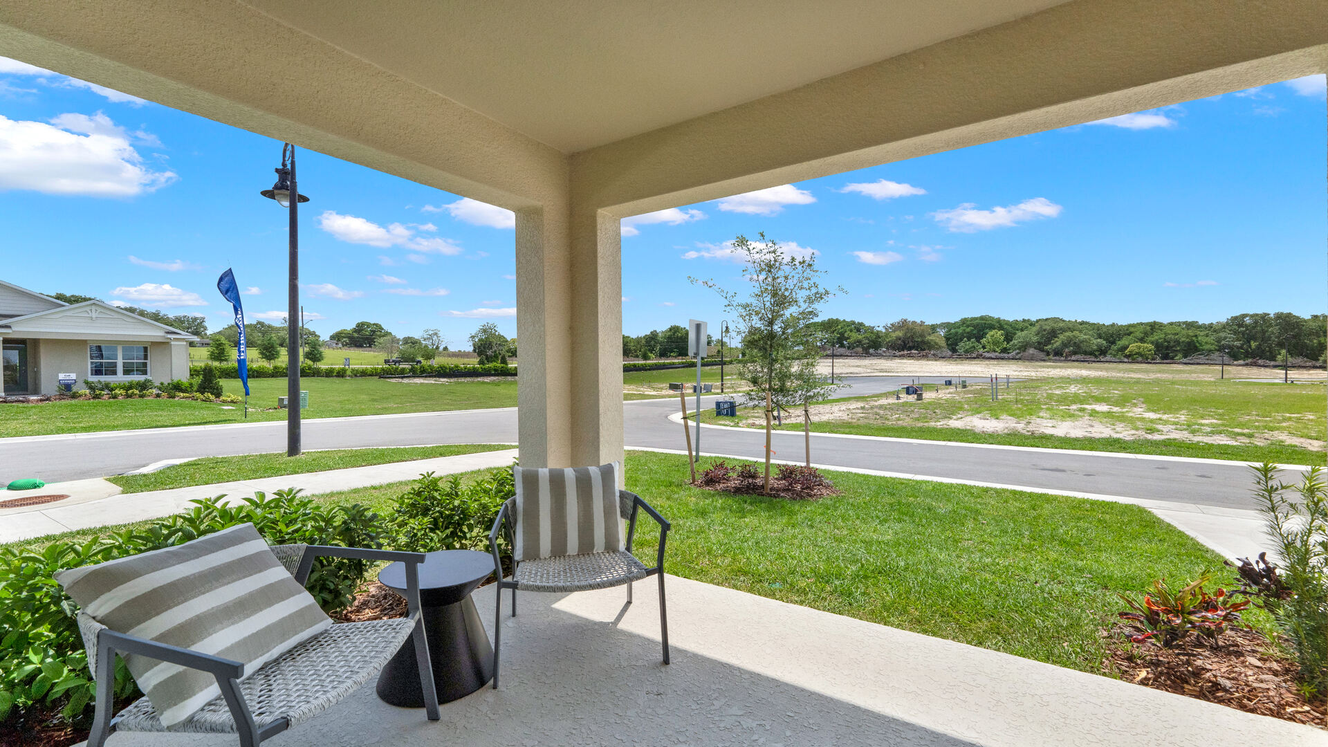 Rear of home with view of grassed backyard, porch seating and slider glass doors.