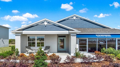Single story new home with siding, covered porch and 2 car garage.