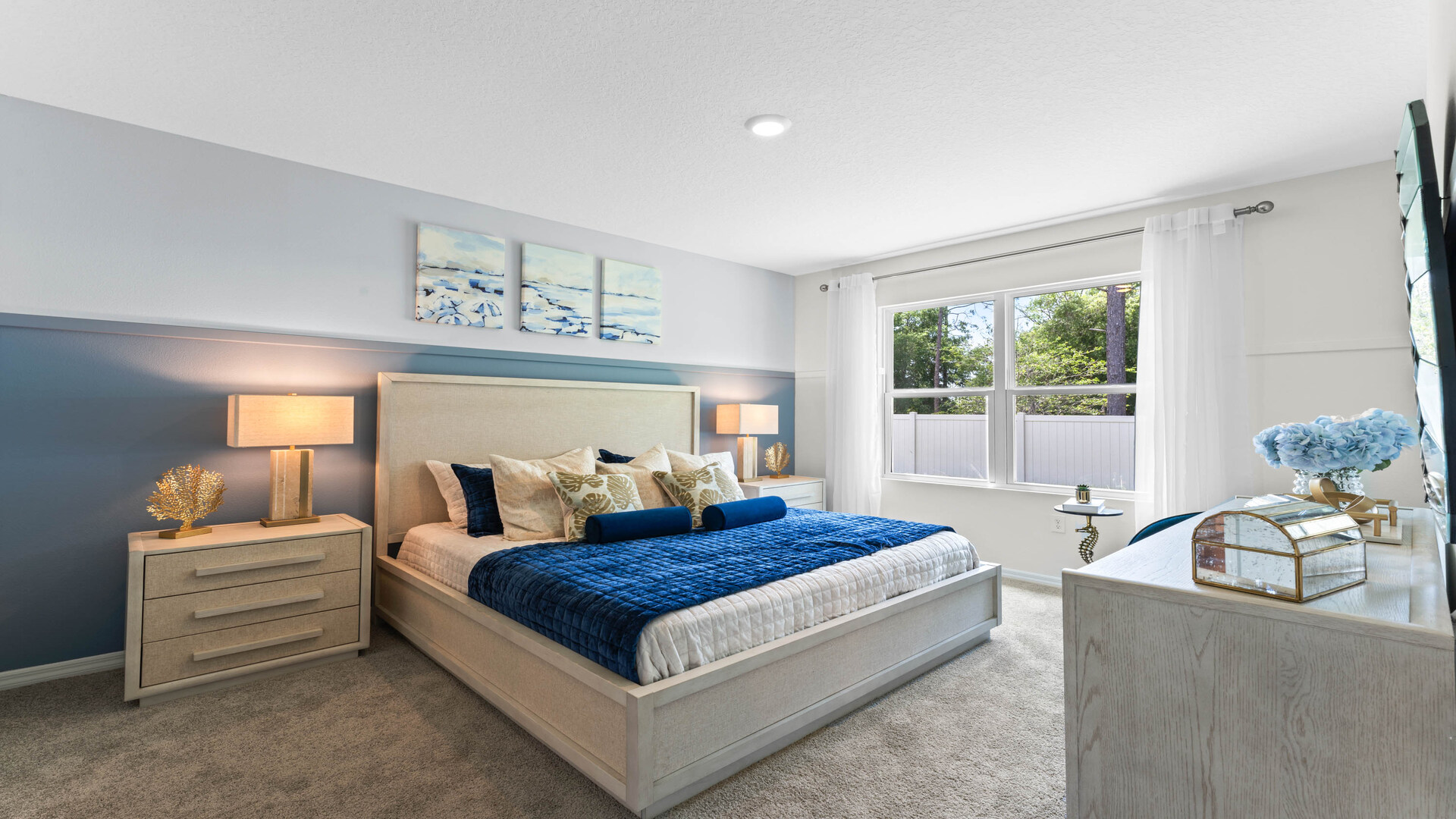 primary bedroom with king sized bed, nighstands and natural lighting.