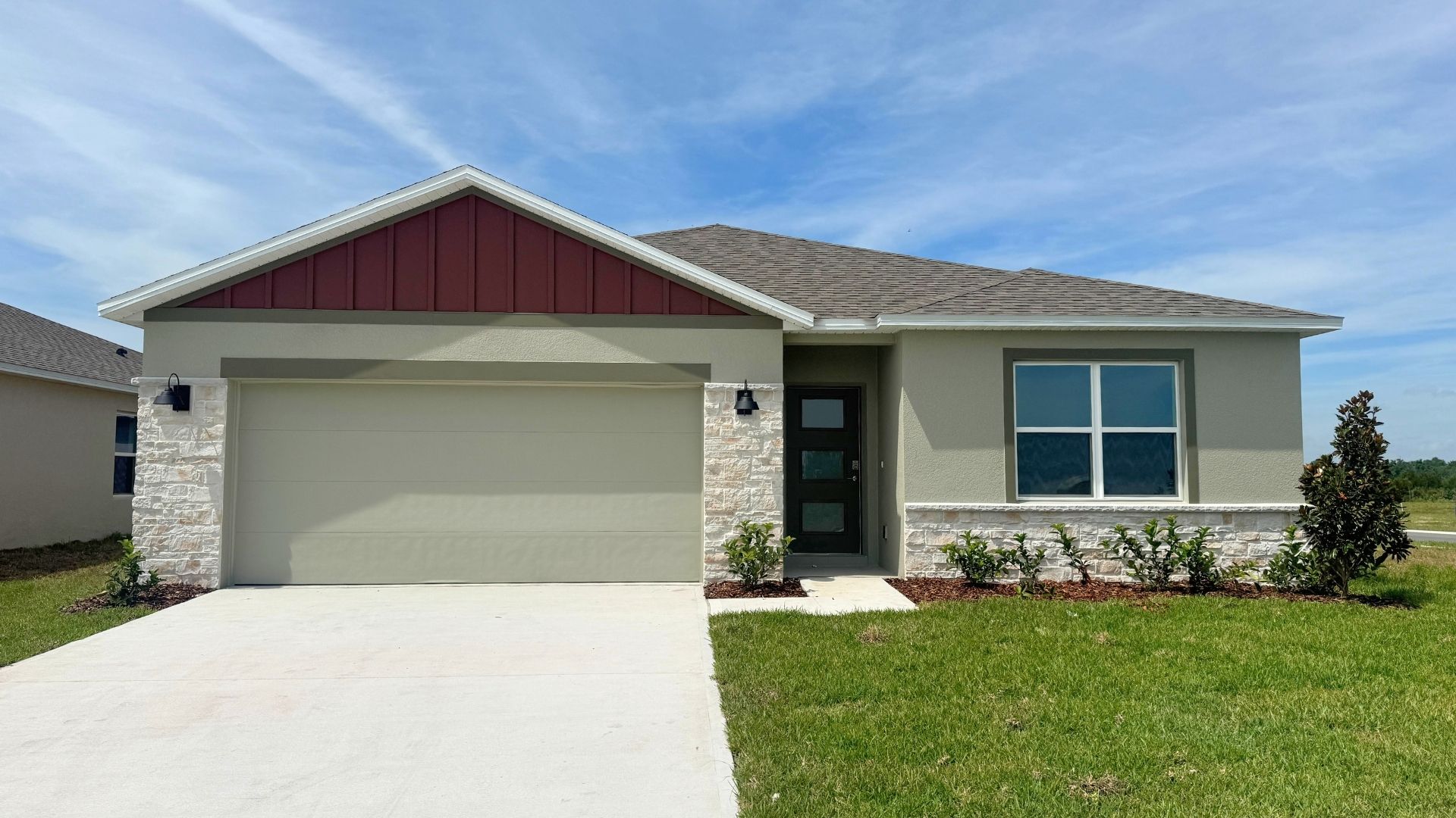 Single story new home with large windows and 2 car garage.