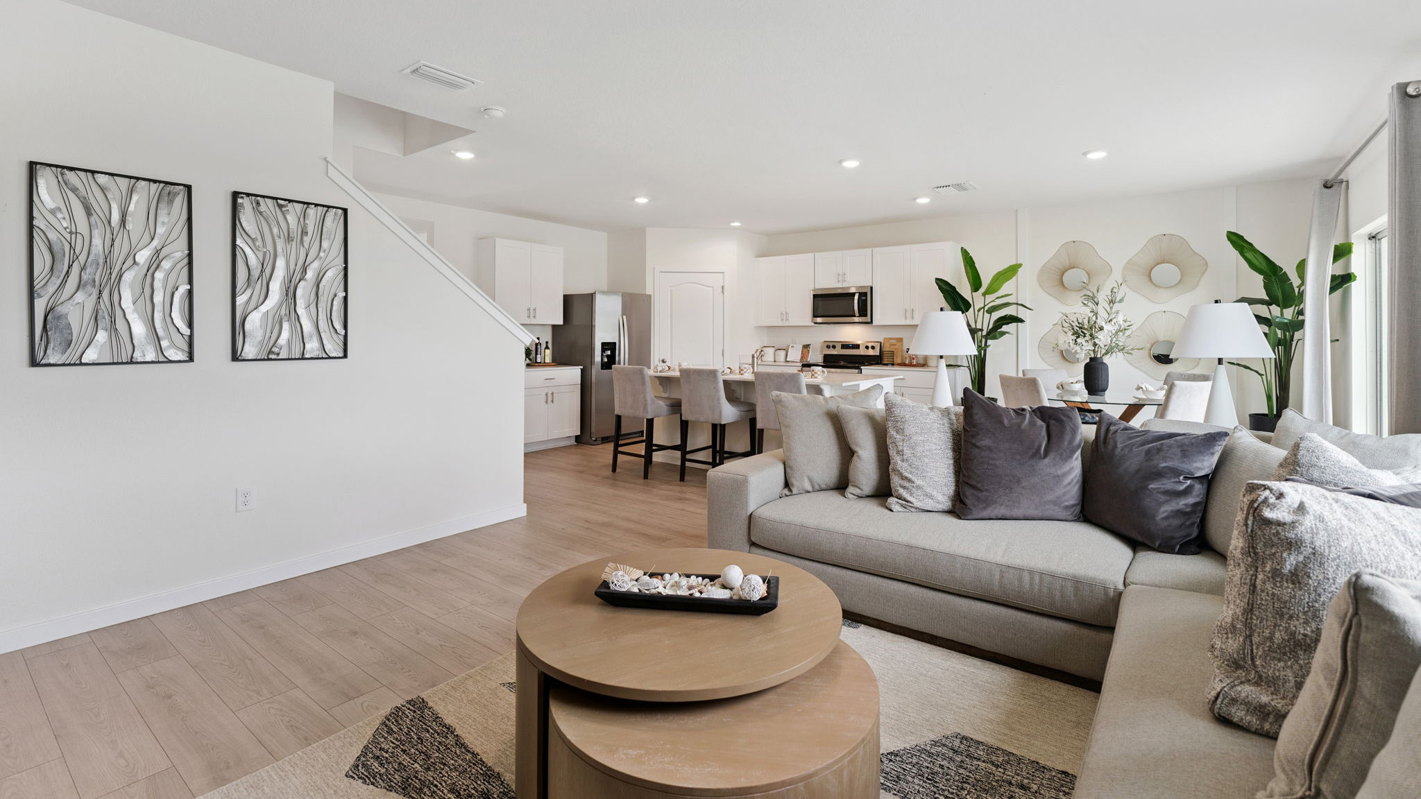 Kitchen with island seating, quartz counters, spacious pantry and stainless steel appliances.