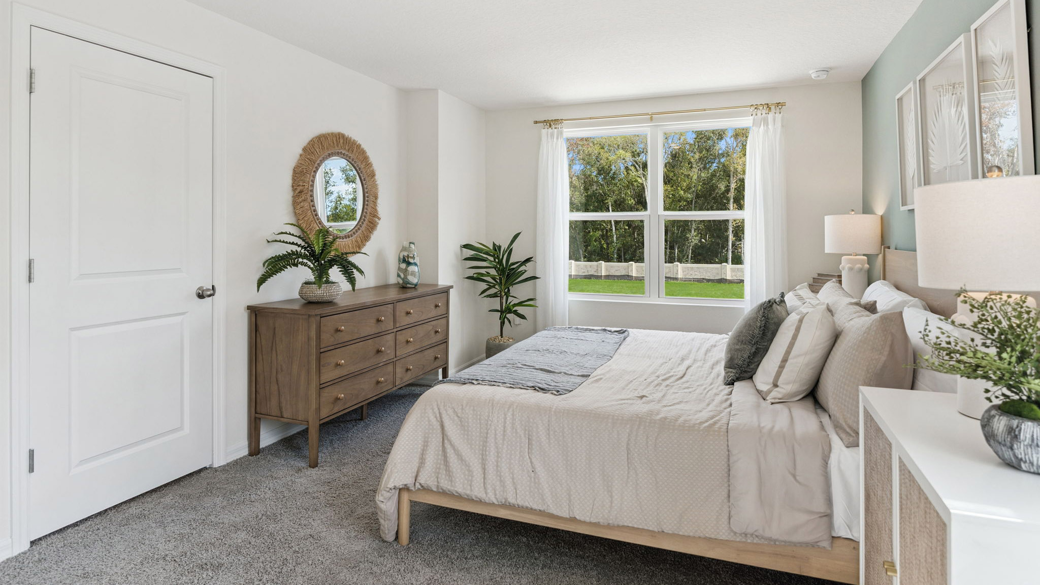 Spacious primary bedroom with king size bed, carpet flooring, natural lighting.