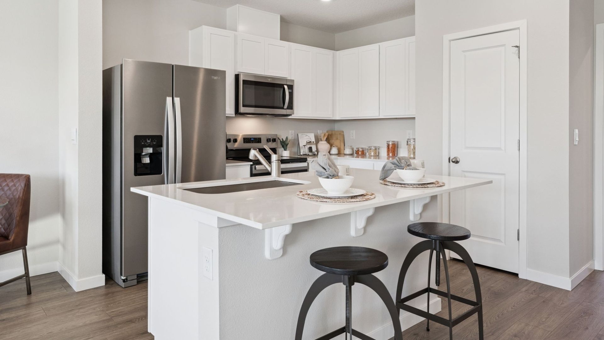kitchen with quartz countertops overseeing living area and dining room table