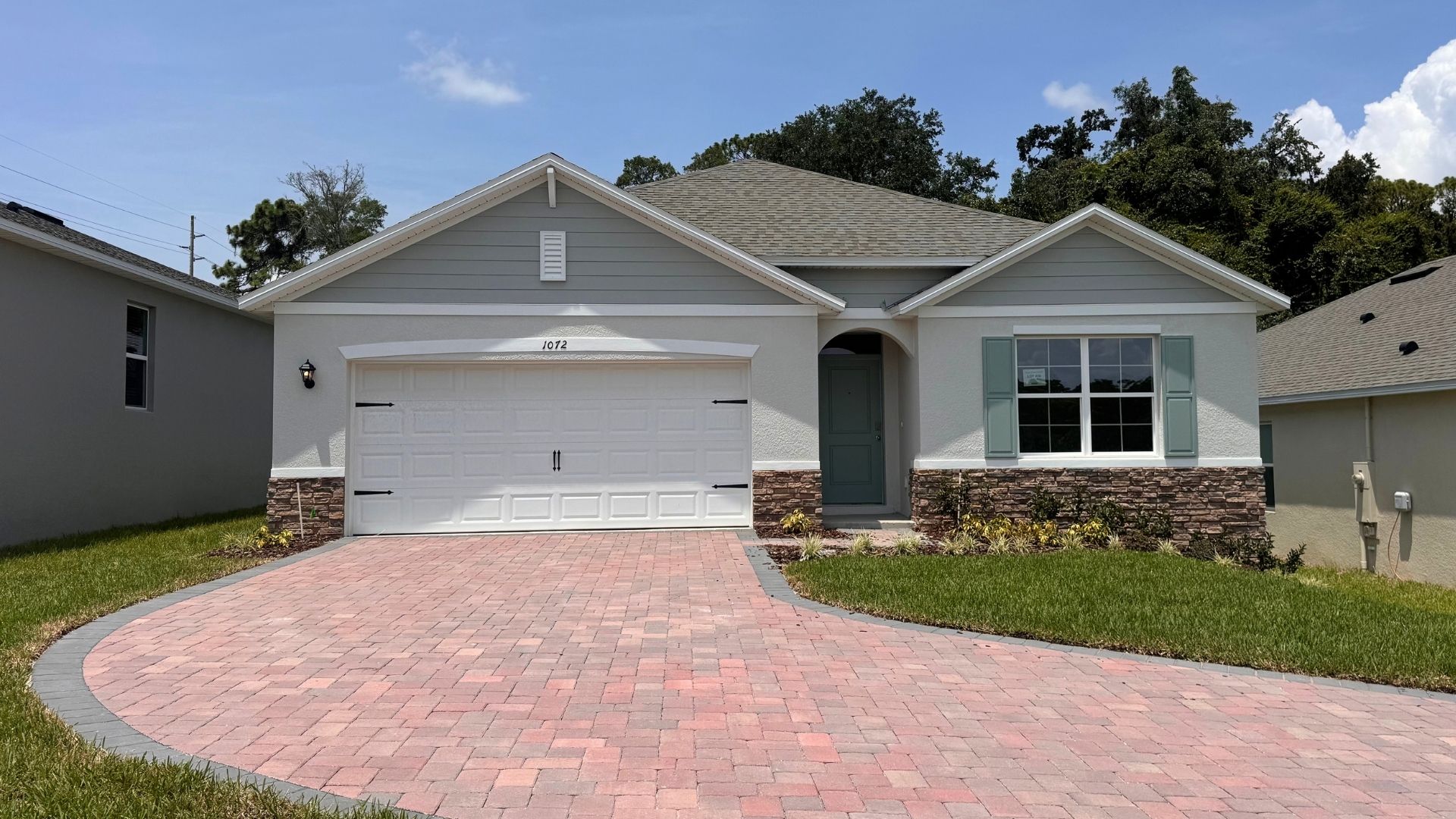 Single story new home with large windows and 2 car garage.