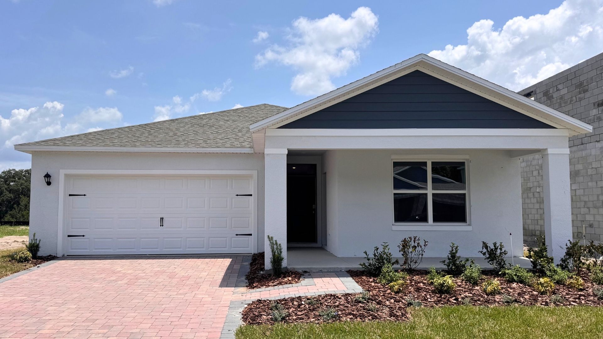 Single story new home with large windows and 2 car garage.