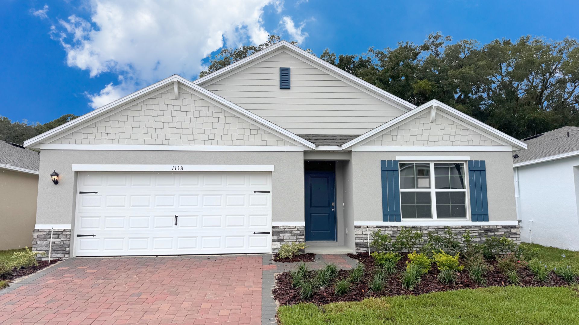 Single story new home with large windows and 2 car garage.