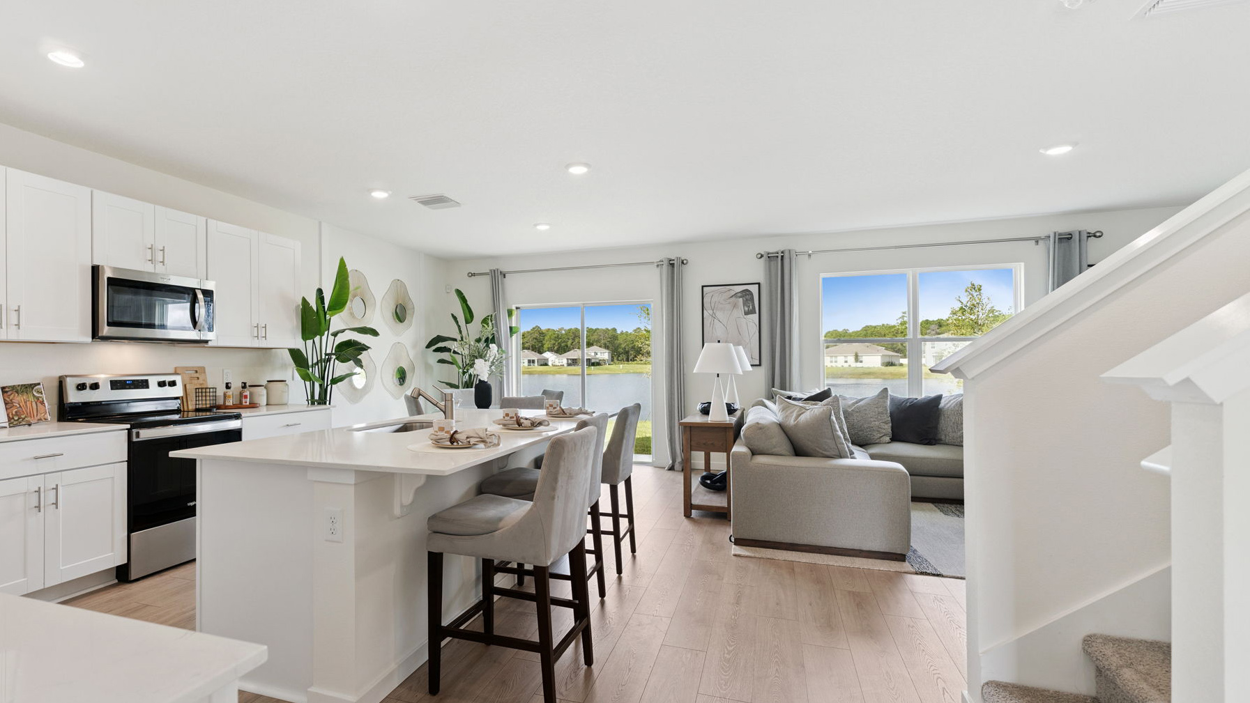 Kitchen with island seating, quartz counters, spacious pantry and stainless steel appliances.