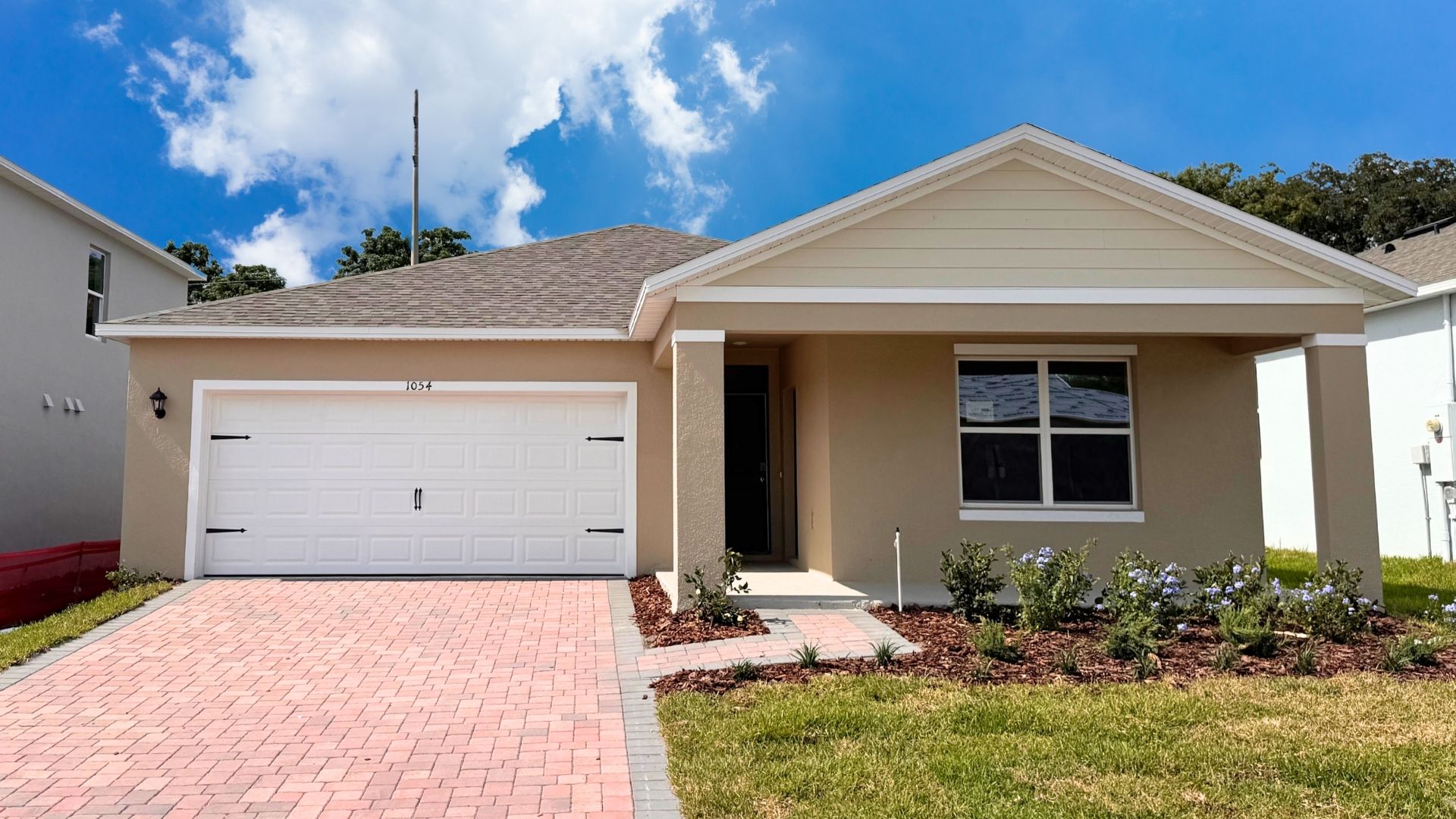 Single story new home with large windows and 2 car garage.