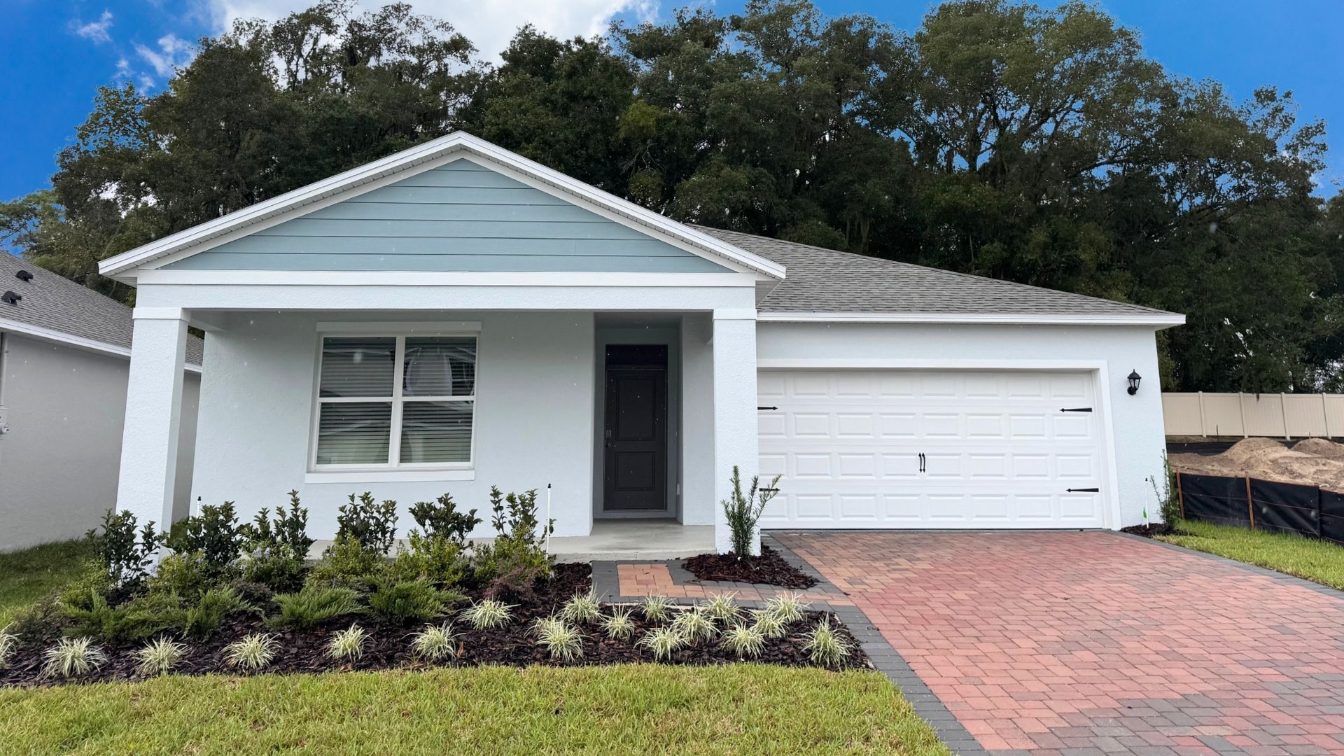 Single story new home with large windows and 2 car garage.