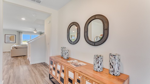 Entry way to home with luxury vinyl plank flooring, adjacent to dining room.