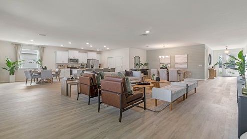 Living area with couch seating, entertainment system and natural lighting.