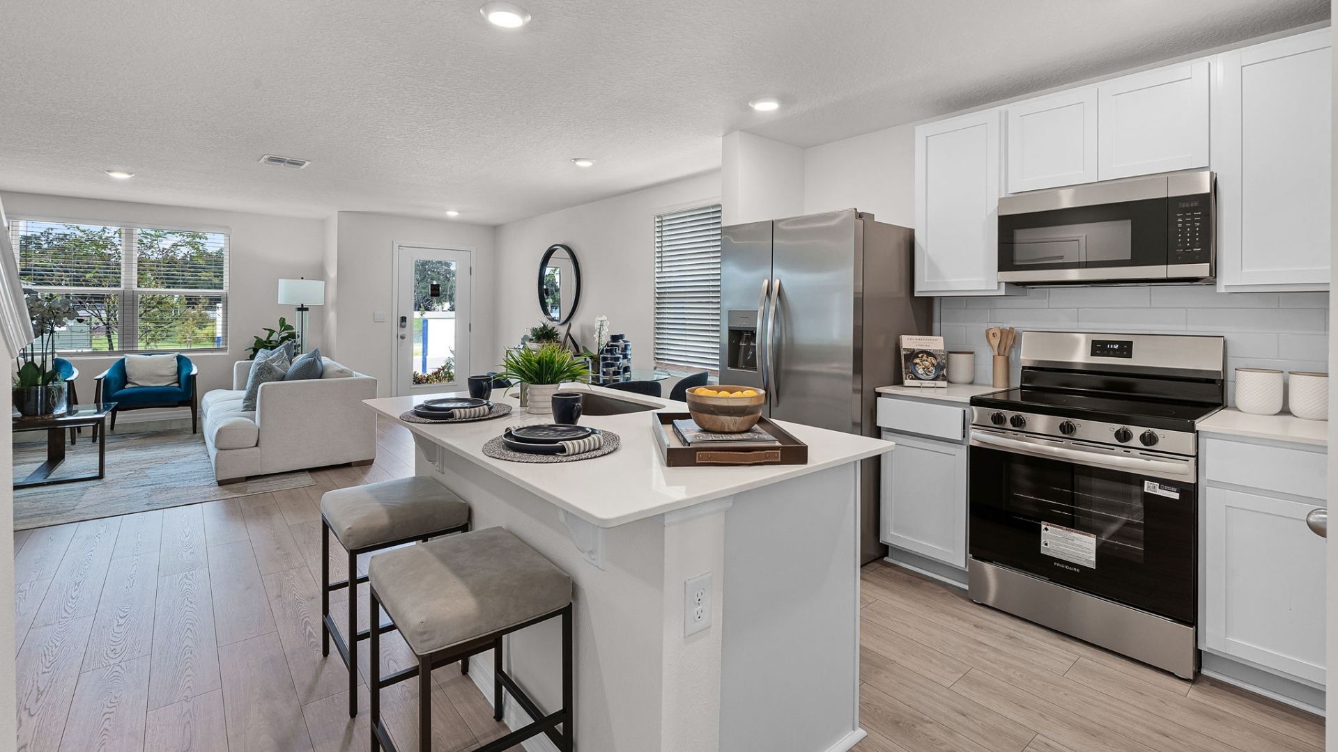 kitchen with quartz countertops overseeing living area and dining room table