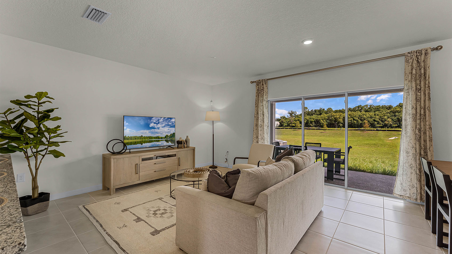Living area with couch seating and access to backyard thru slidingdoor.