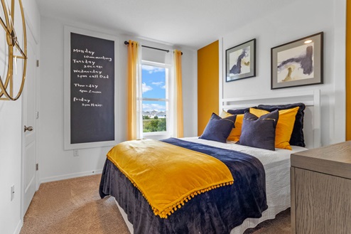 Primary bedroom with bed and spare chair