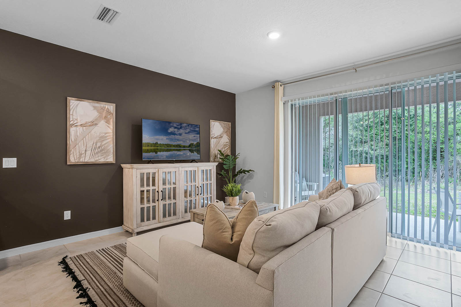 Living room with sofa, tv and patio doors to covered lanai