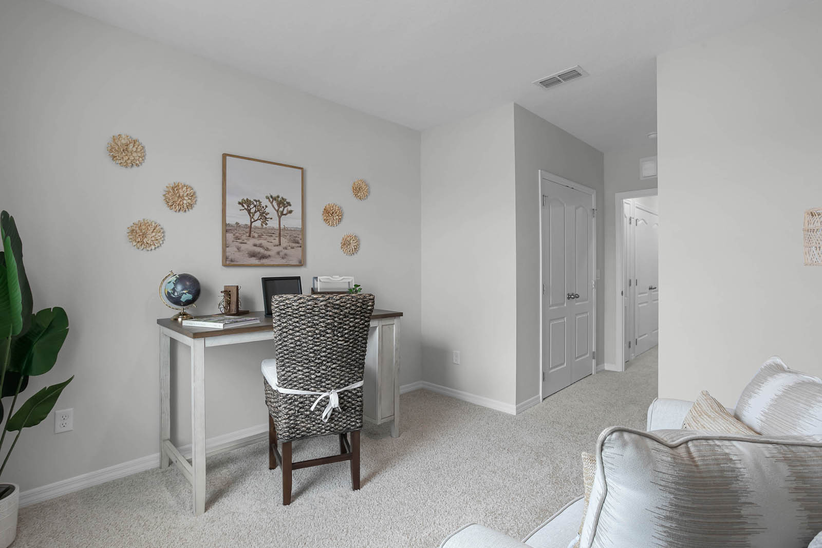 guest room staged as an office with desk and chair