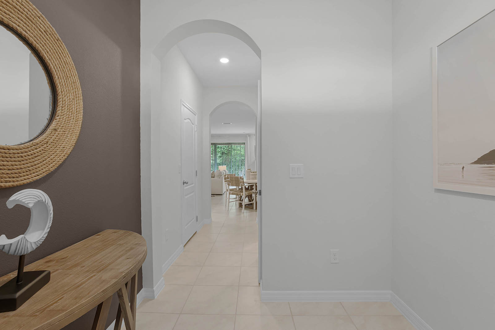 Entrance with table and mirror and hallway leading to kitchen