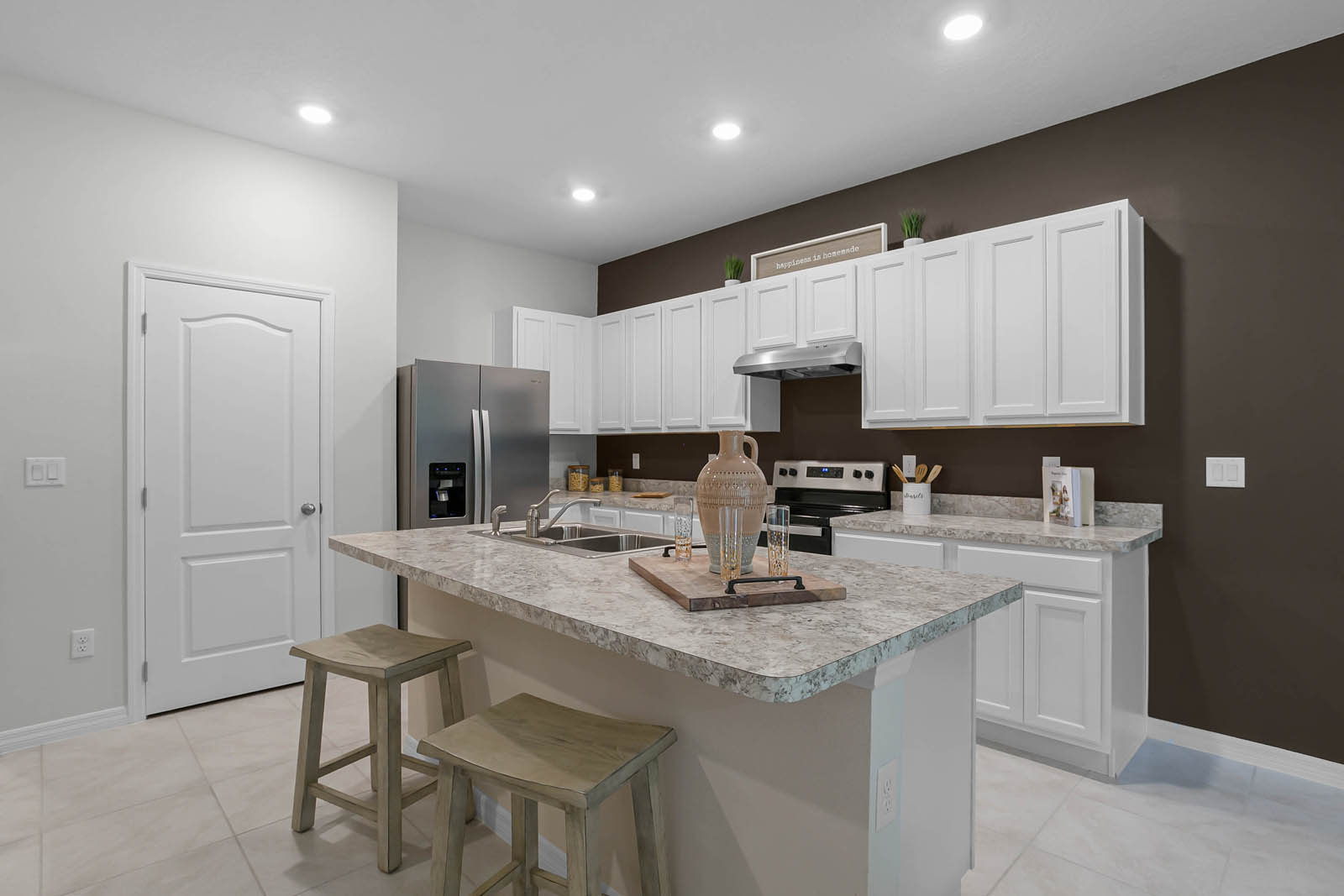 Spacious kitchen with white cabinets and large island with seating