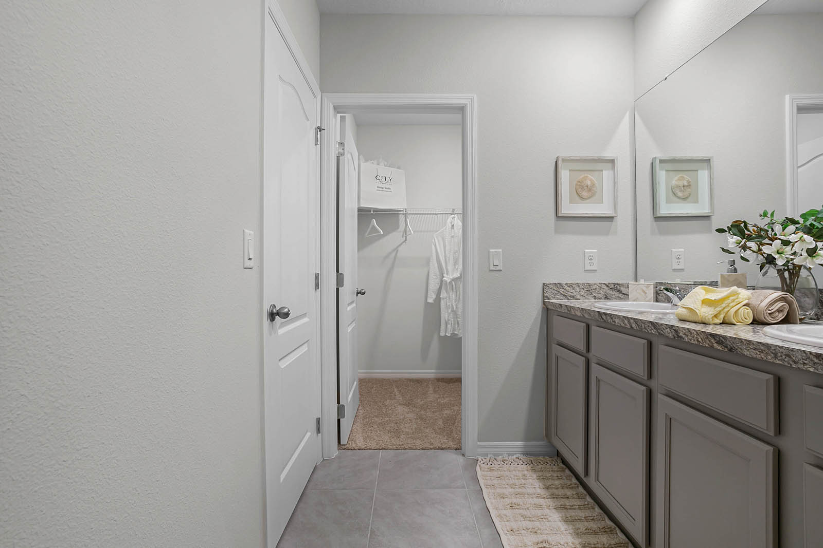 Primary bathroom with double vanity sink and walk in closet
