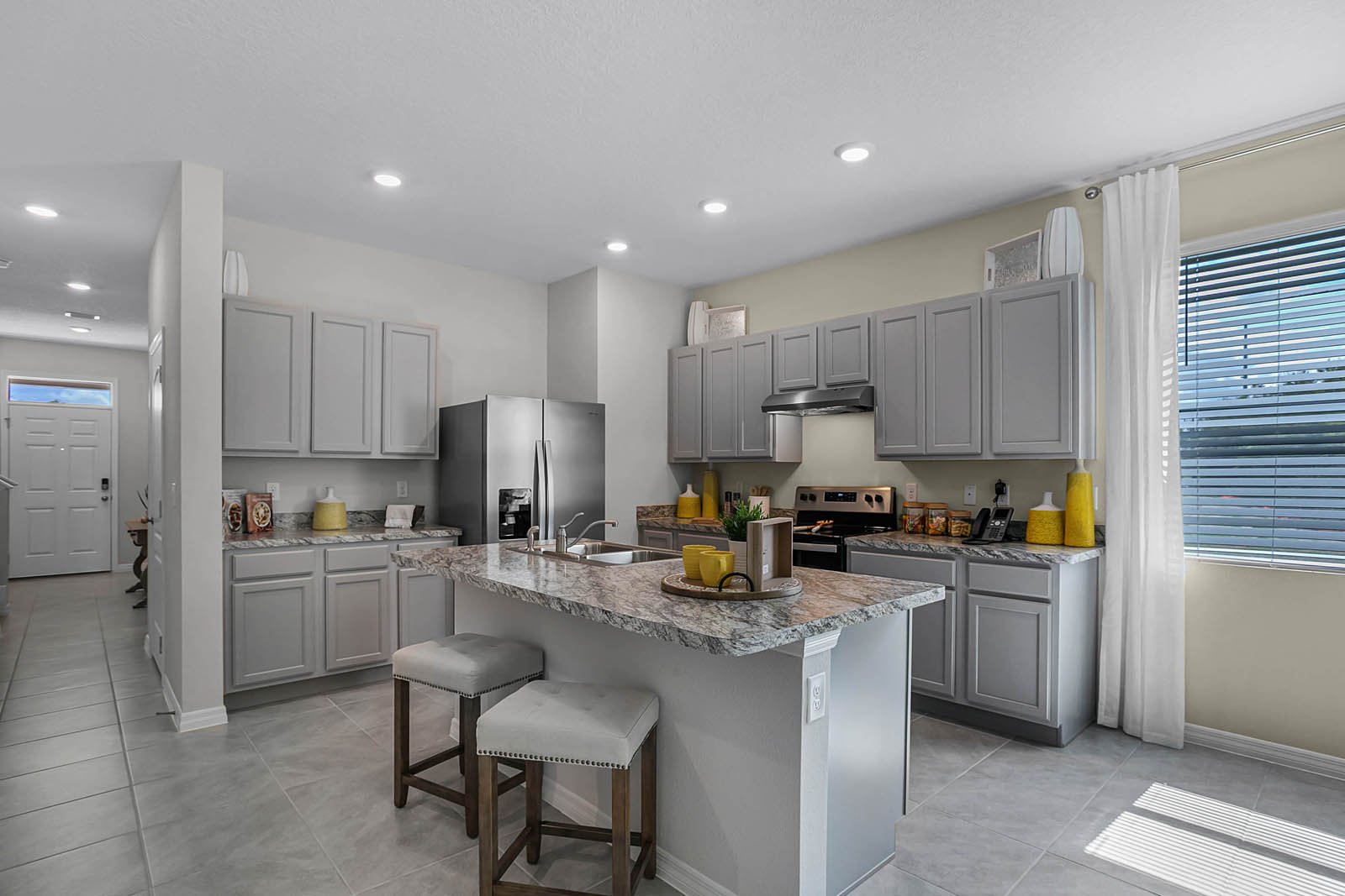 Open concept kitchen with seating at island overlooking the great room