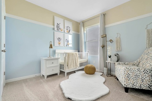 nursery with crib and carpet throughout