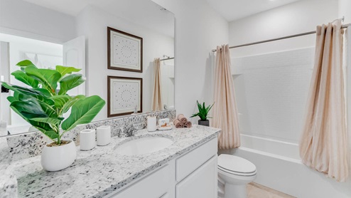 Bathroom connected to two guest rooms with single sink vanity and tub