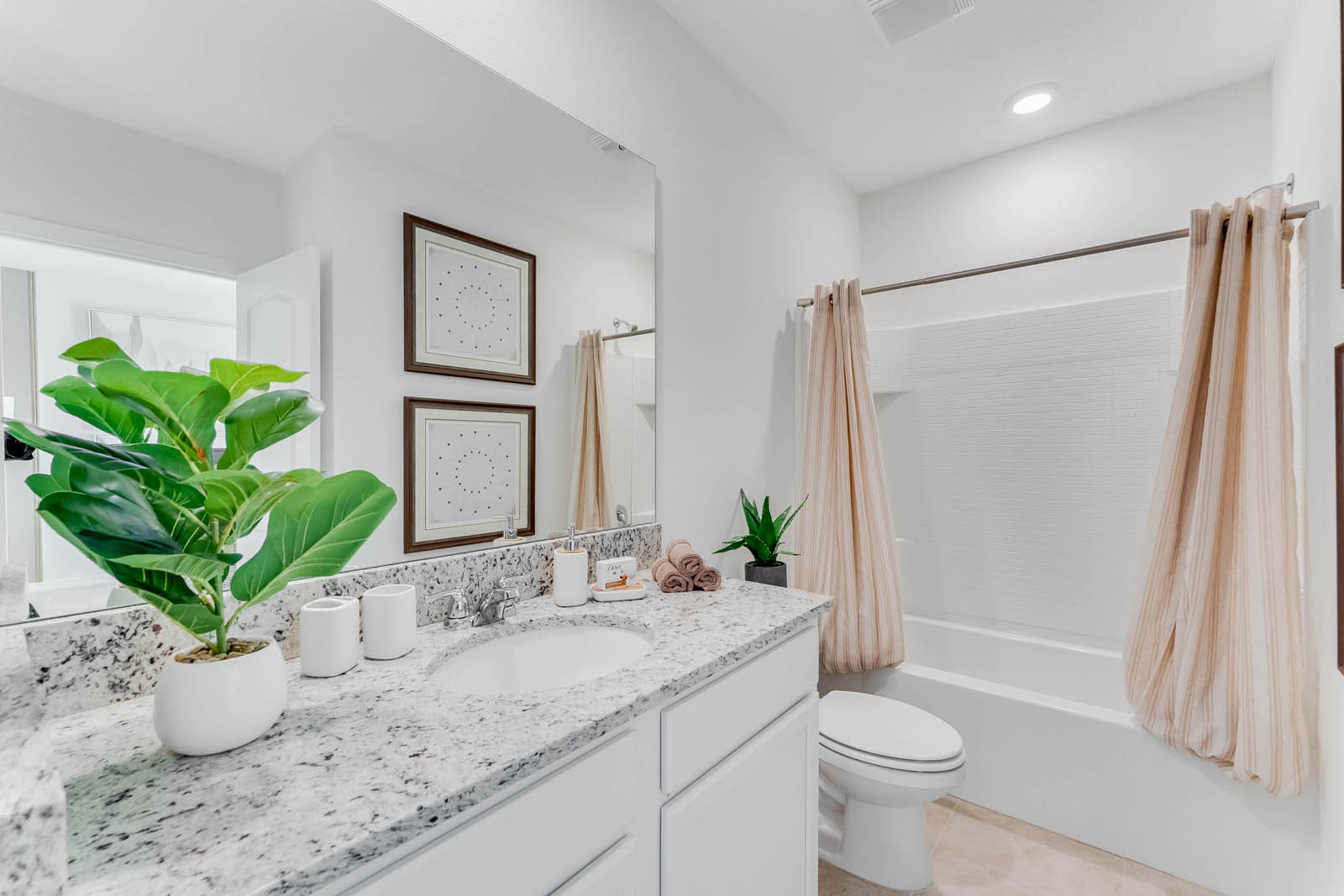 Upstairs guest shared bathroom with double vanity sinks and tub