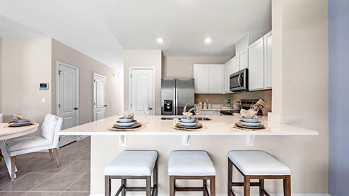 Spacious kitchen with peninsula overlooking living room and additional seating