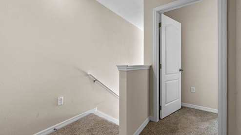 Upstairs hallway leading to first floor and primary bedroom