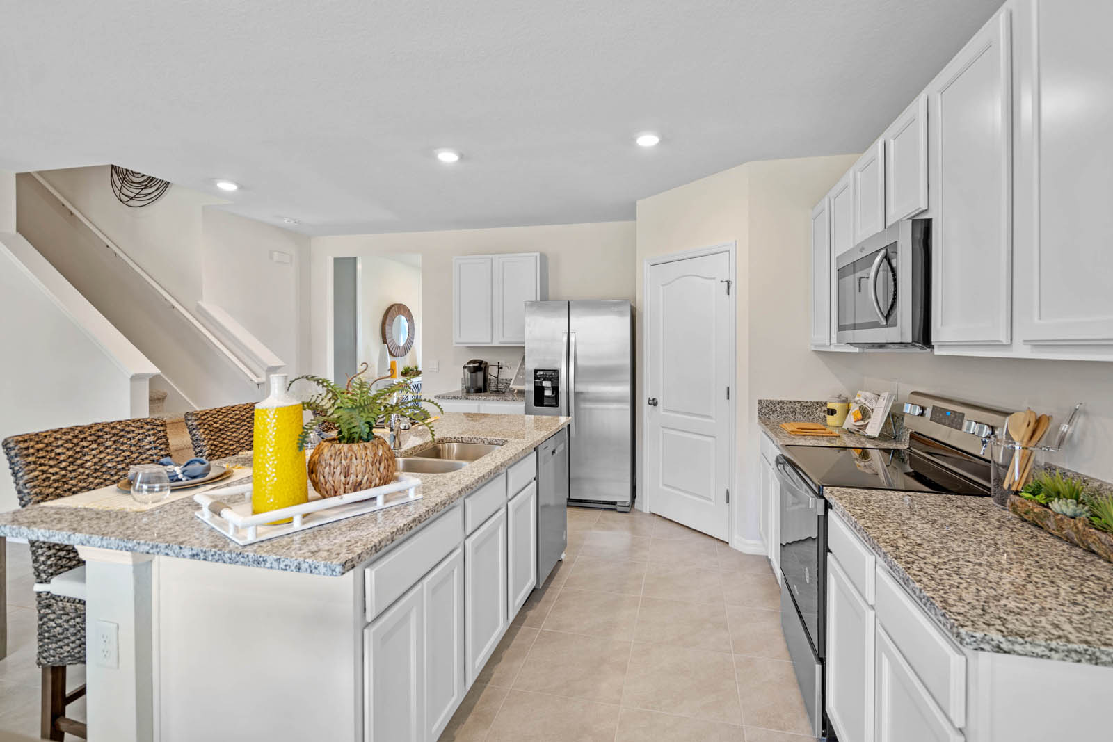 Kitchen island with sink adjacent to the stove and microwave