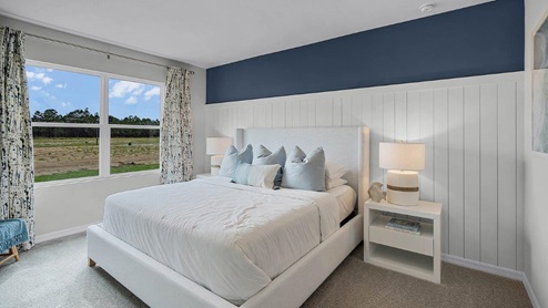 Primary bedroom with windows facing the backyard