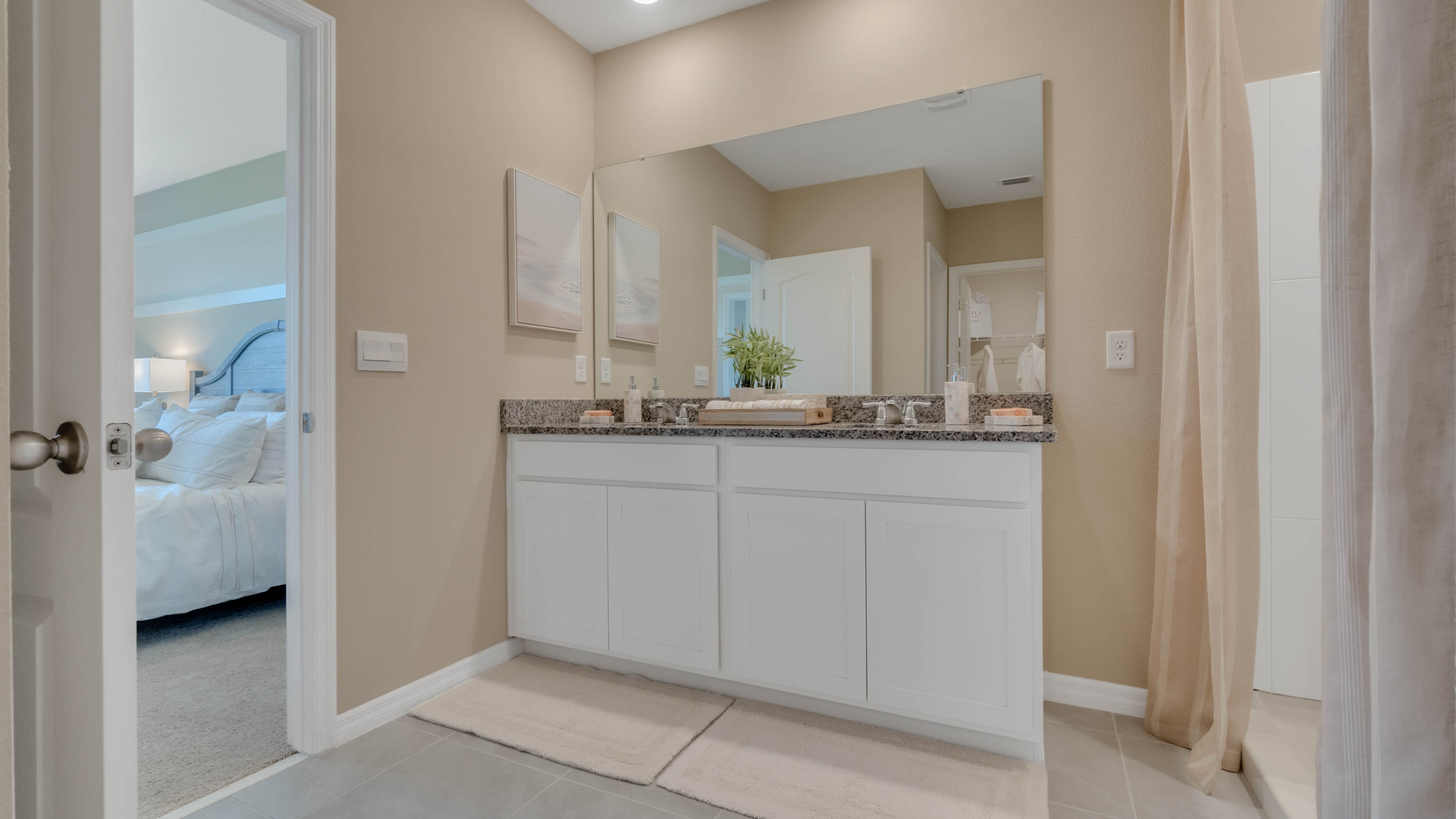 Primary bedroom with double sink and walk in shower