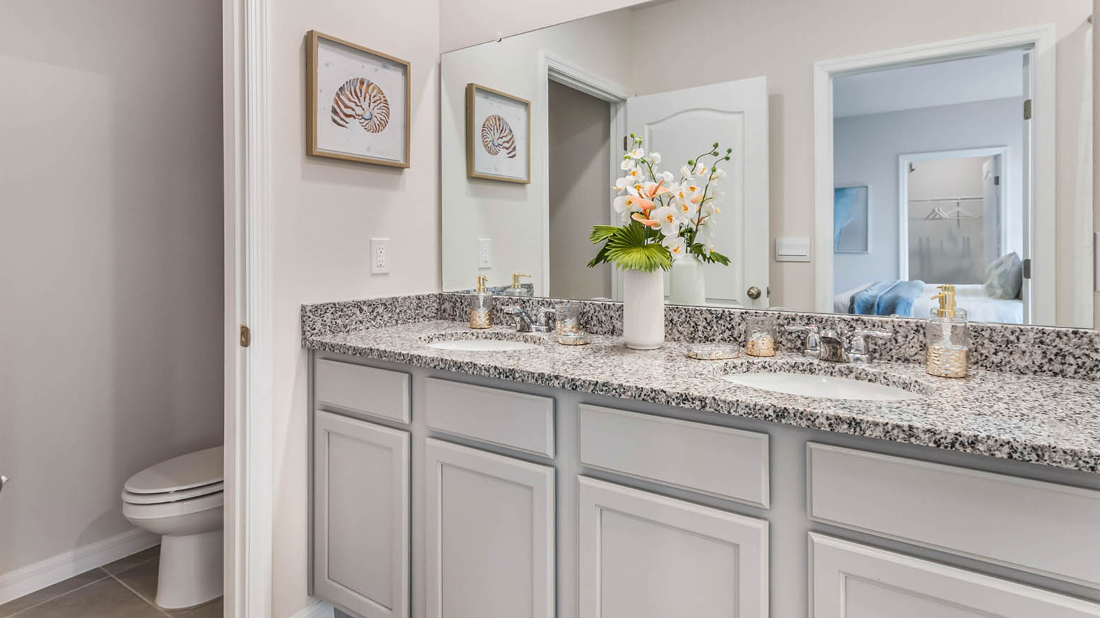 Primary bathroom with double vanity sinks and gray cabinets