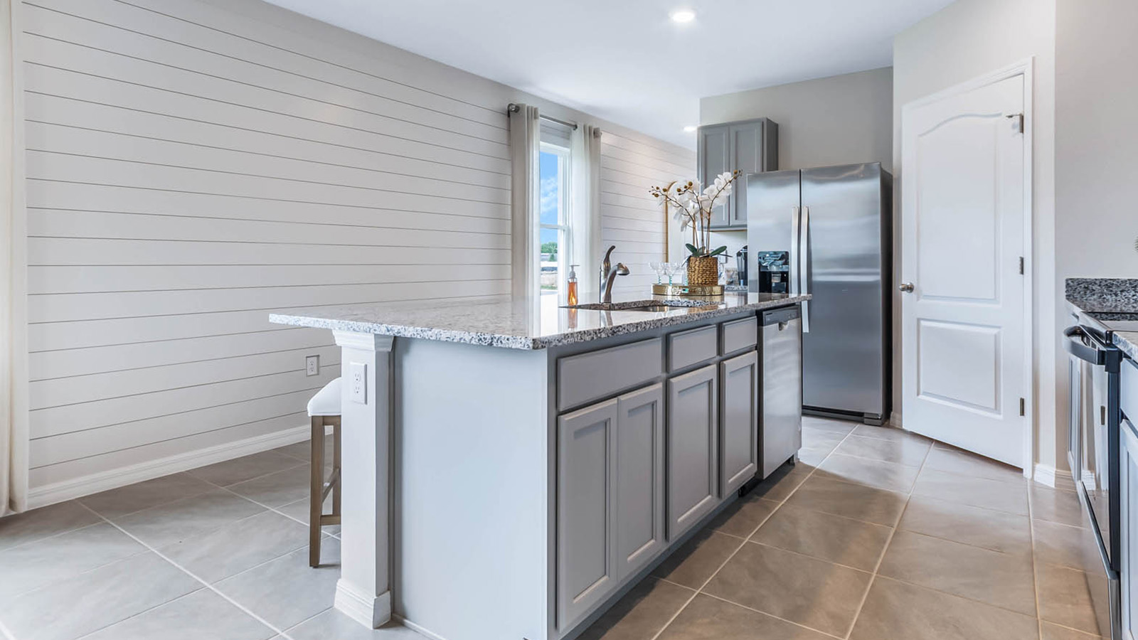 Kitchen island with gray cabinets and built in sink