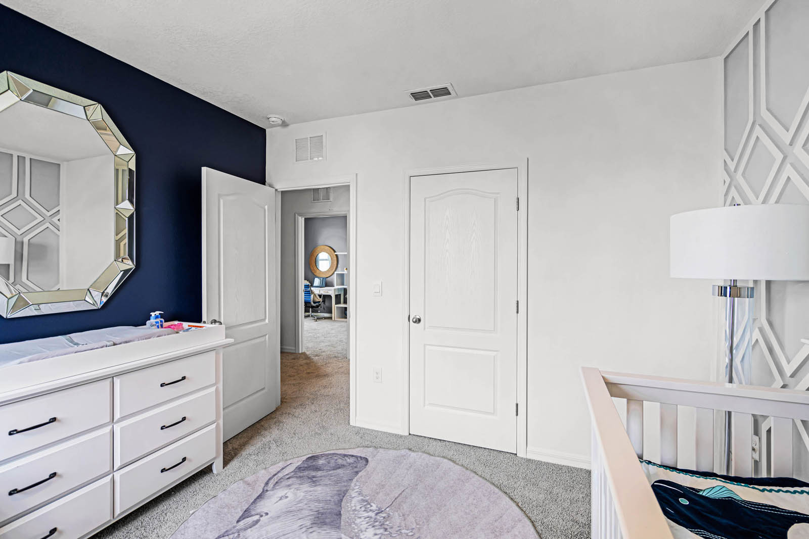 Spare room nursery with crib and changing table and carpet throughout