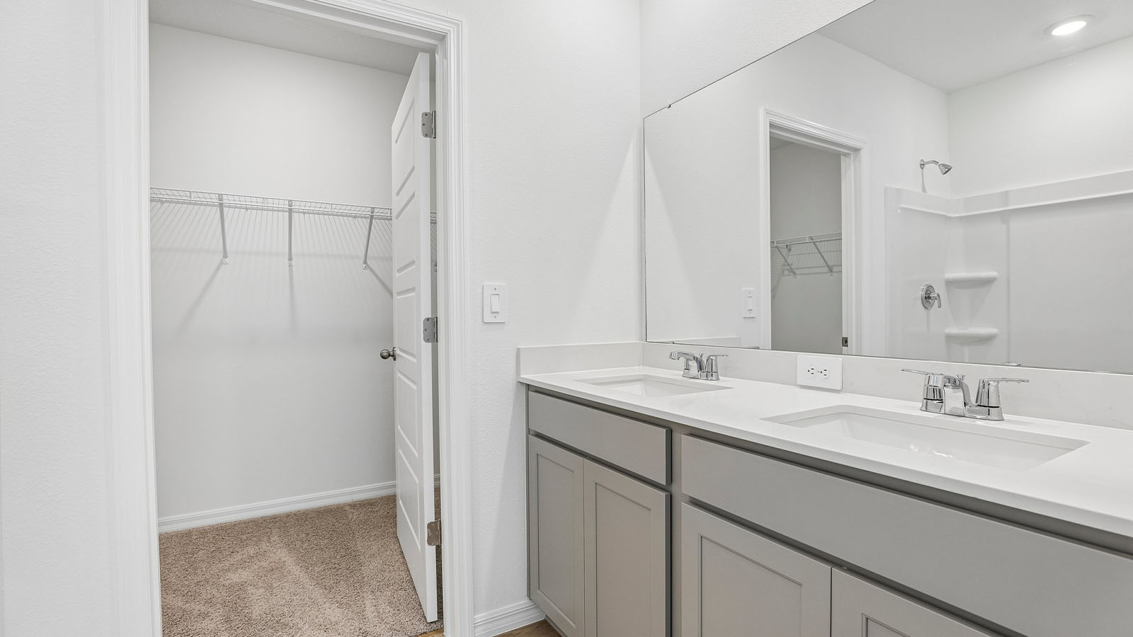 Primary bathroom with double vanity and walk-in closet