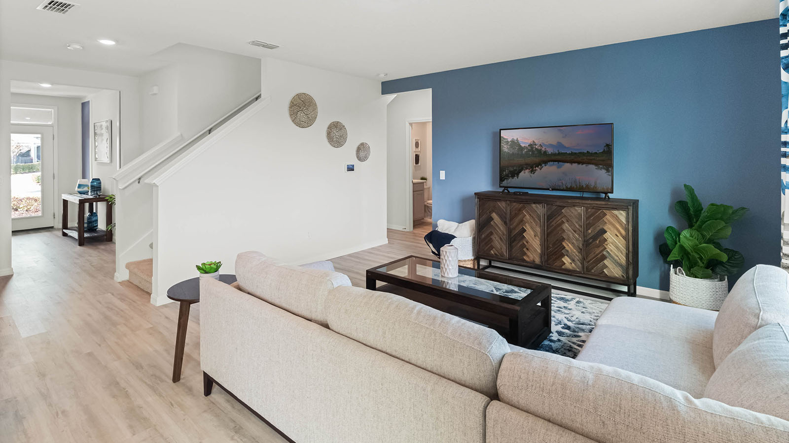Living room with view to the entrance and stairs to second floor