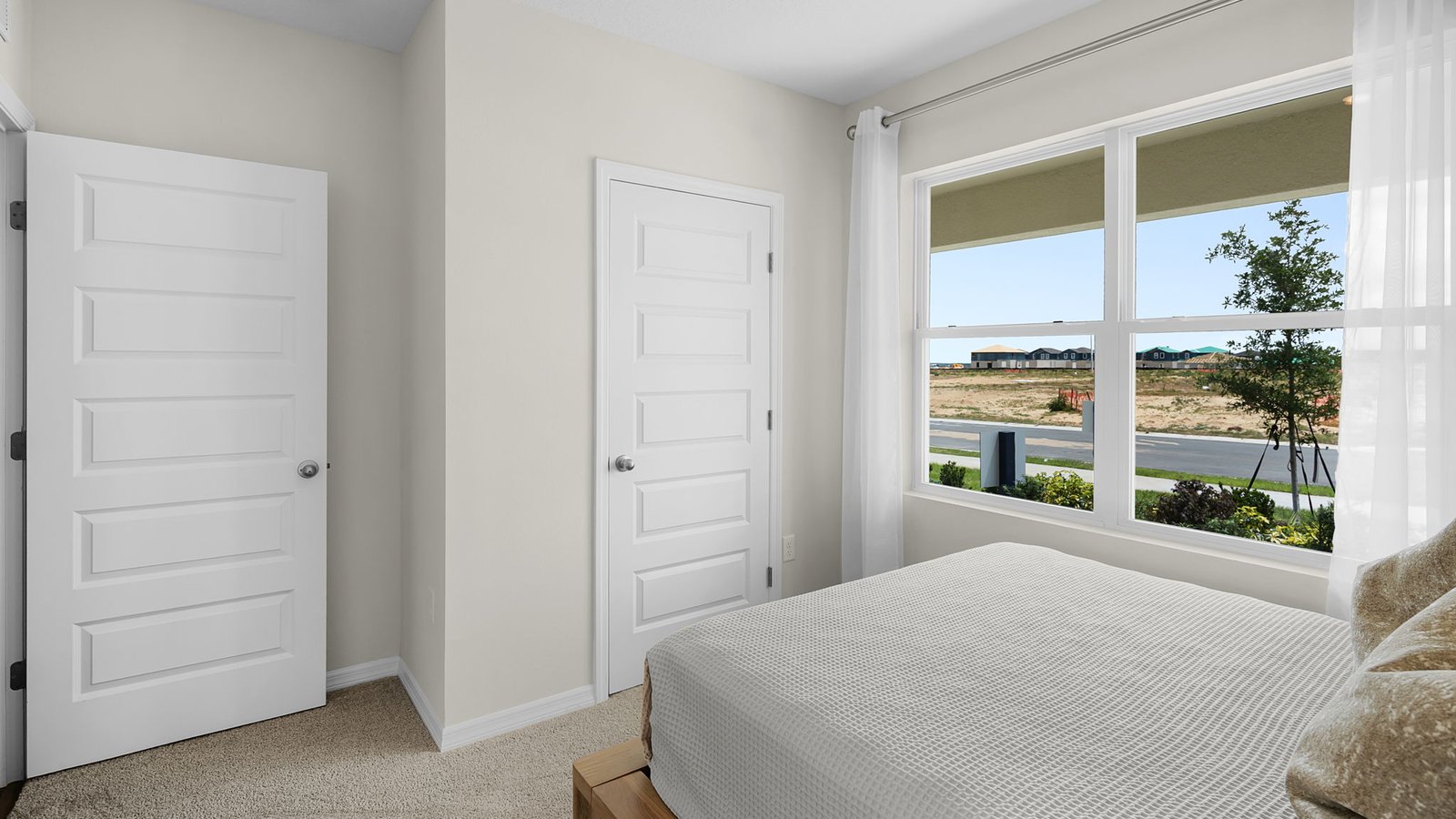 Guest bedroom with large windows and carpet