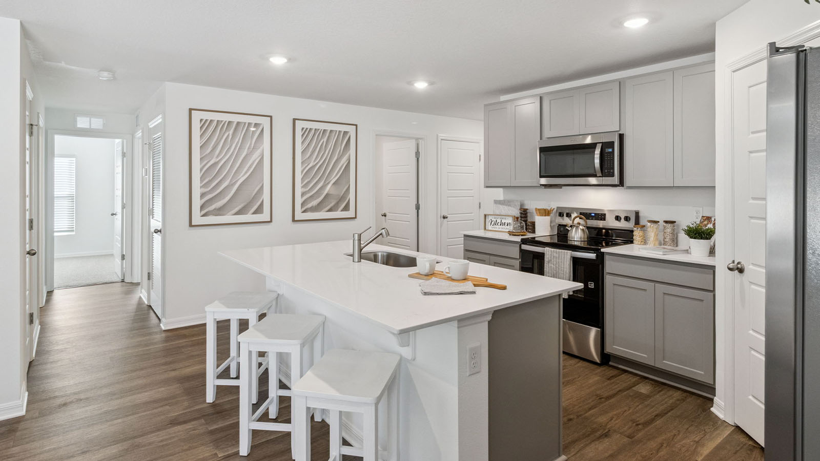 Kitchen with large island and view to second hallway